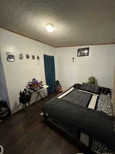 Bedroom with a textured ceiling and hardwood / wood-style floors