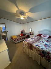 Carpeted bedroom with a textured ceiling and ceiling fan