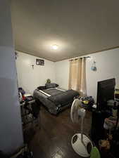 Bedroom with hardwood / wood-style flooring and a textured ceiling