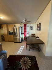 Dining room featuring a textured ceiling, light tile patterned floors, and ceiling fan