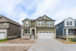 Craftsman-style home featuring a standing seam roof, a garage, metal roof, board and batten siding, and concrete driveway