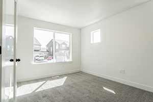 Empty room with baseboards, visible vents, and carpet floors