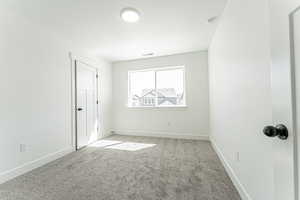 Spare room featuring baseboards, visible vents, light colored carpet, and a textured ceiling