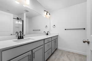 Bathroom featuring tile patterned floors and dual bowl vanity