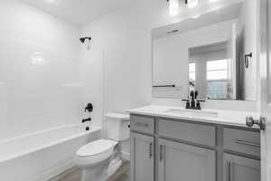 Full bathroom featuring shower / washtub combination, wood-type flooring, toilet, and vanity