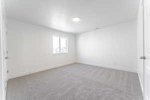 Empty room featuring baseboards, visible vents, carpet floors, and a textured ceiling