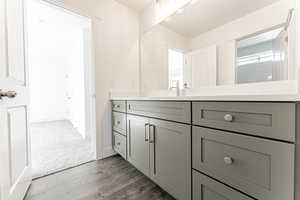 Bathroom featuring baseboards, wood finished floors, and vanity