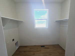 Laundry area featuring hookup for an electric dryer and dark hardwood / wood-style flooring