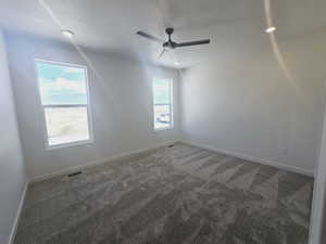 Unfurnished room featuring a textured ceiling, ceiling fan, and carpet flooring