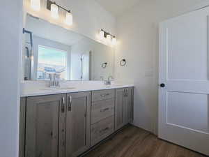 Bathroom with dual vanity and hardwood / wood-style flooring