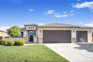 Prairie-style home featuring a garage and a front yard