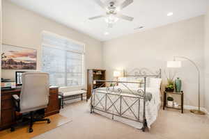 Carpeted bedroom featuring ceiling fan