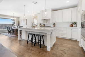 Kitchen featuring a breakfast bar area, light hardwood / wood-style flooring, sink, and an island with sink