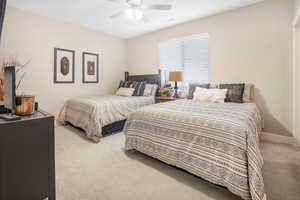 Carpeted bedroom featuring ceiling fan