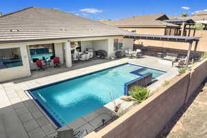 View of swimming pool with an in ground hot tub and a patio area