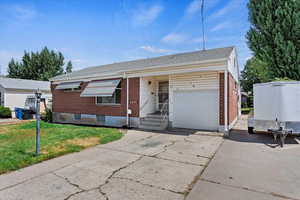 Ranch-style home with a front yard and a garage