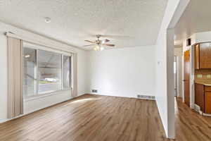 Interior space featuring ceiling fan, light hardwood / wood-style floors, and a textured ceiling