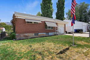 View of front of property featuring a garage and a front lawn