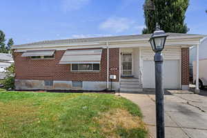 View of front of home featuring a garage and a front lawn