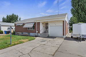 Single story home with a garage and a front yard