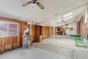 Miscellaneous room featuring ceiling fan, plenty of natural light, concrete floors, and lofted ceiling