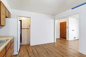 Kitchen featuring white fridge and light hardwood / wood-style flooring