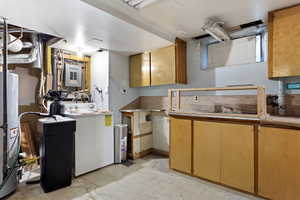 Kitchen with washer / clothes dryer, light tile patterned floors, and water heater