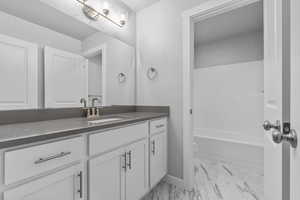 Full bathroom with vanity, toilet, and washtub / shower combination