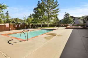 View of swimming pool featuring a patio and a hot tub