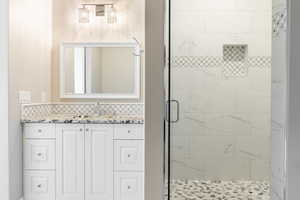 Bathroom with a shower with shower door and vanity