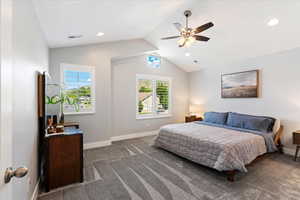 Bedroom with lofted ceiling, dark colored carpet, and ceiling fan