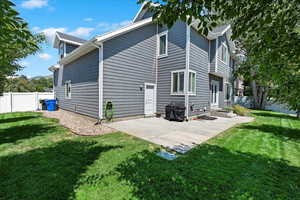 Rear view of house with a patio area and a lawn