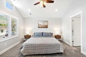 Bedroom with ceiling fan, lofted ceiling, and carpet flooring