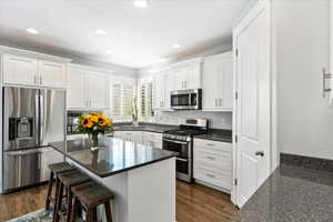 Kitchen featuring white cabinetry, dark wood-type flooring, and stainless steel appliances