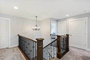 Hall with a notable chandelier and carpet floors