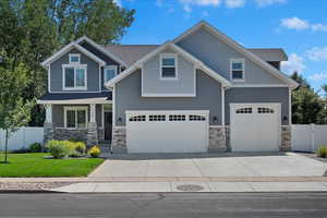 Craftsman inspired home featuring a garage and a front yard