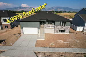 View of front of property with a mountain view and a garage