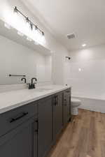 Full bathroom featuring vanity, bathtub / shower combination, toilet, and hardwood / wood-style flooring