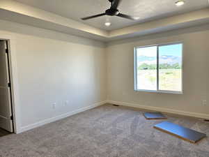 Unfurnished room featuring a textured ceiling, carpet floors, and ceiling fan