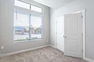 Unfurnished bedroom with a closet, light colored carpet, and a textured ceiling