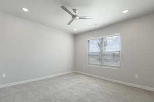 Carpeted empty room featuring ceiling fan