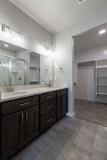 Bathroom with tile patterned floors, a shower with door, and dual vanity