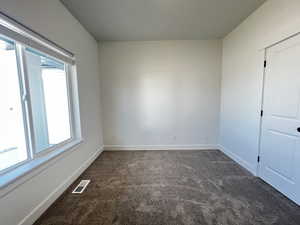 Unfurnished room with dark carpet