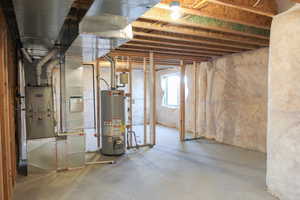 Basement featuring heating unit and water heater