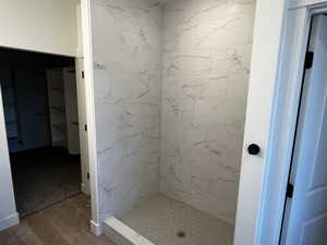 Bathroom featuring hardwood / wood-style floors and a tile shower