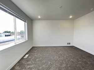 Unfurnished room with dark colored carpet