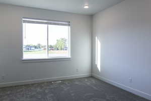 Carpeted empty room featuring a healthy amount of sunlight