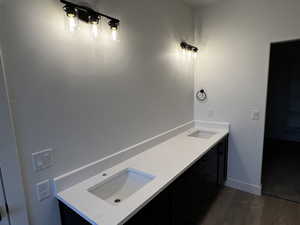 Bathroom with wood-type flooring and dual vanity