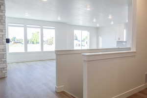 Kitchen featuring light wood-type flooring, white cabinetry, kitchen peninsula, and tasteful backsplash