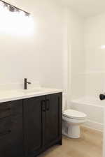 Bathroom featuring hardwood / wood-style floors, vanity, and toilet